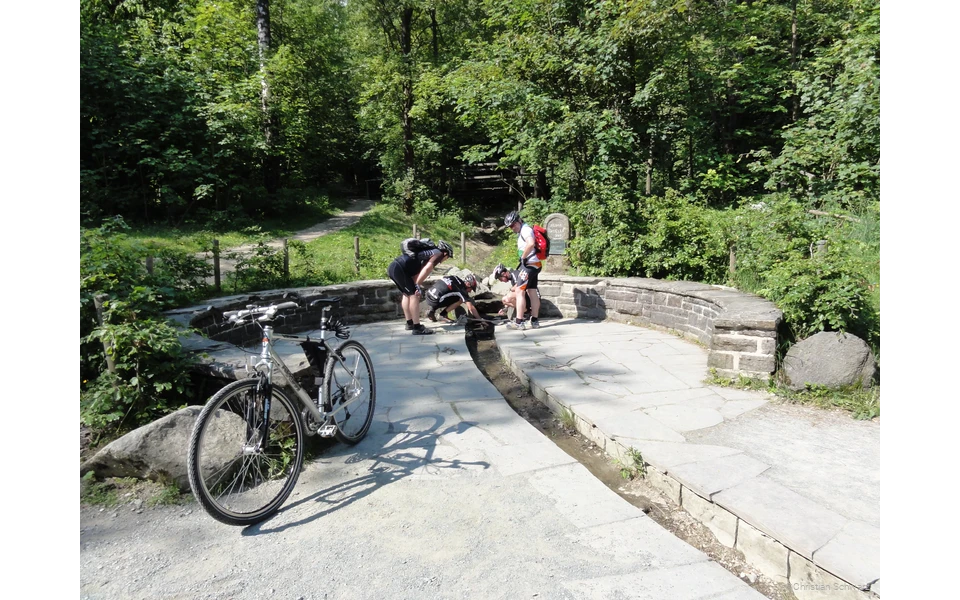 Radler bestaunen das Rinnsal der Ruhr an der Ruhrquelle